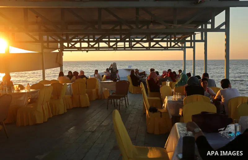 Palestinians are seen aboard "Lolo Rose" ship which has become a popular restaurant, on a beach in Gaza City on August 4, 2017. Photo by Ashraf Amra