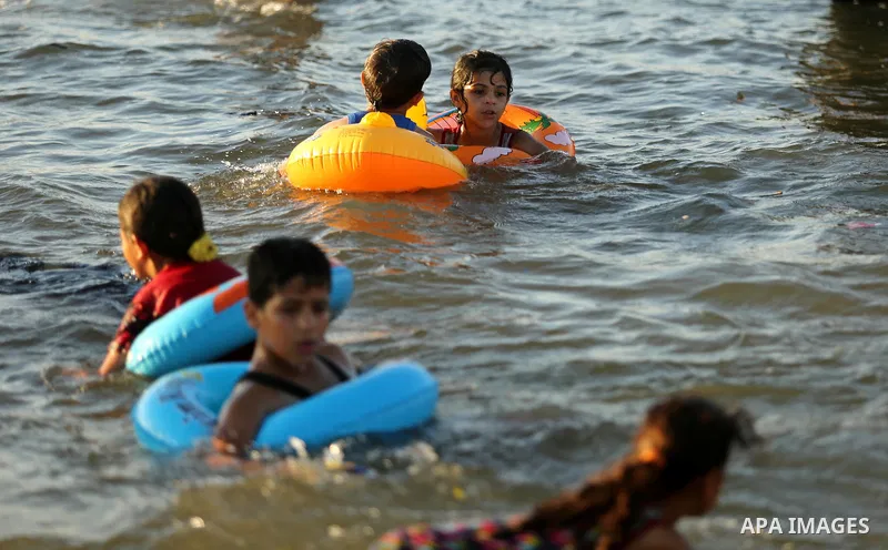Palestinians enjoy their time at the beach of the Mediterranean sea on the coast of Gaza city on August 4, 2017. Photo by Ashraf Amra