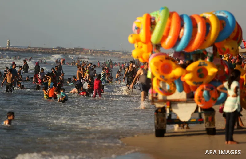 Palestinians enjoy their time at the beach of the Mediterranean sea on the coast of Gaza city on August 4, 2017. Photo by Ashraf Amra
