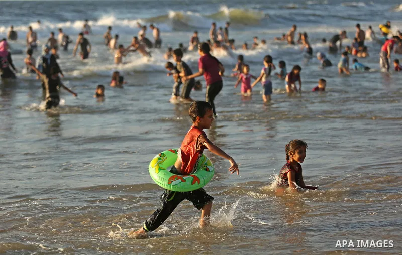Palestinians enjoy their time at the beach of the Mediterranean sea on the coast of Gaza city on August 4, 2017. Photo by Ashraf Amra