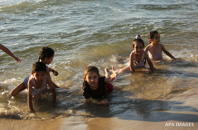 Palestinians enjoy their time at the beach of the Mediterranean sea on the coast of Gaza city on August 4, 2017. Photo by Ashraf Amra