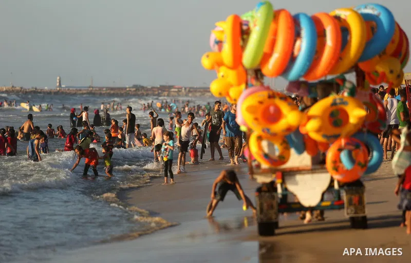 Palestinians enjoy their time at the beach of the Mediterranean sea on the coast of Gaza city on August 4, 2017. Photo by Ashraf Amra