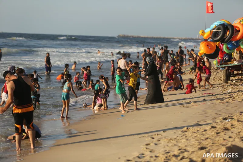 Palestinians enjoy their time at the beach of the Mediterranean sea on the coast of Gaza city on August 4, 2017. Photo by Ashraf Amra