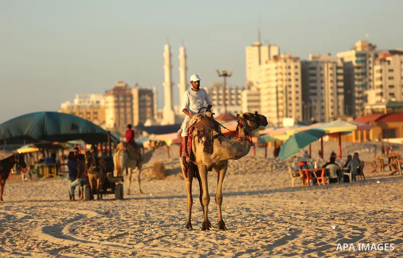 Palestinians enjoy their time at the beach of the Mediterranean sea on the coast of Gaza city on August 4, 2017. Photo by Ashraf Amra