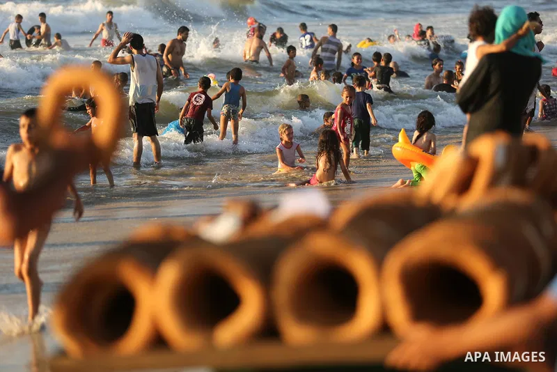 Palestinians enjoy their time at the beach of the Mediterranean sea on the coast of Gaza city on August 4, 2017. Photo by Ashraf Amra