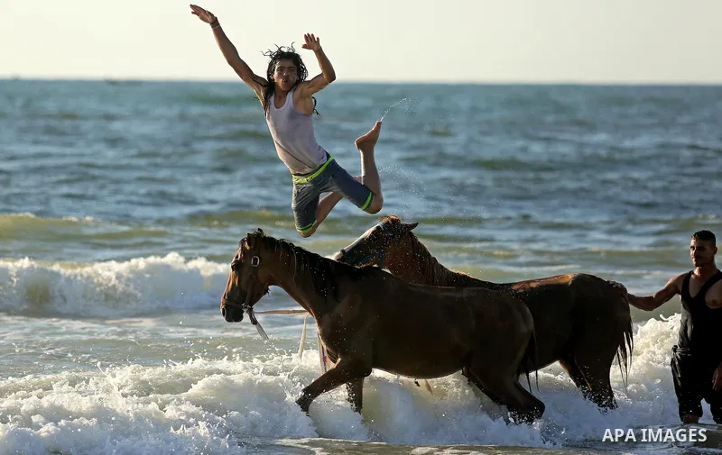 Palestinians enjoy their time at the beach of the Mediterranean sea on the coast of Gaza city on August 4, 2017. Photo by Ashraf Amra
