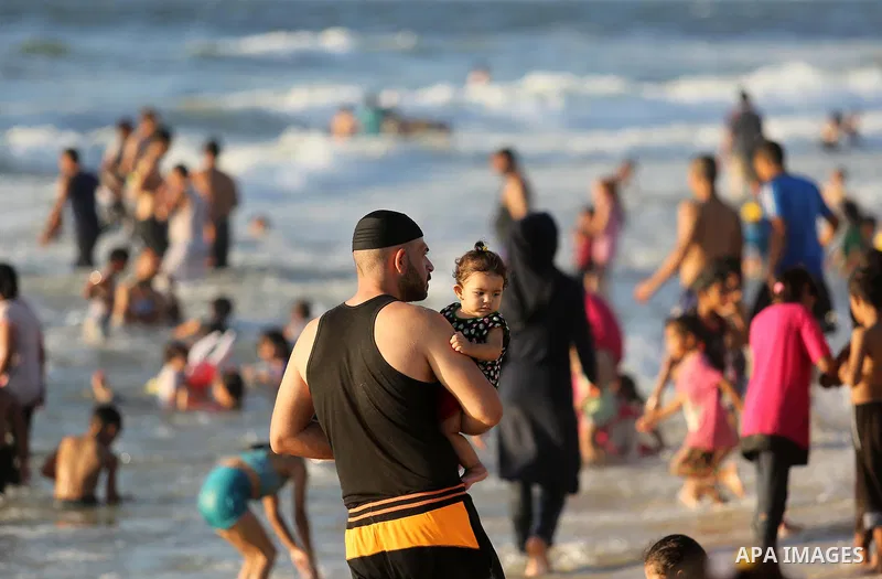 Palestinians enjoy their time at the beach of the Mediterranean sea on the coast of Gaza city on August 4, 2017. Photo by Ashraf Amra