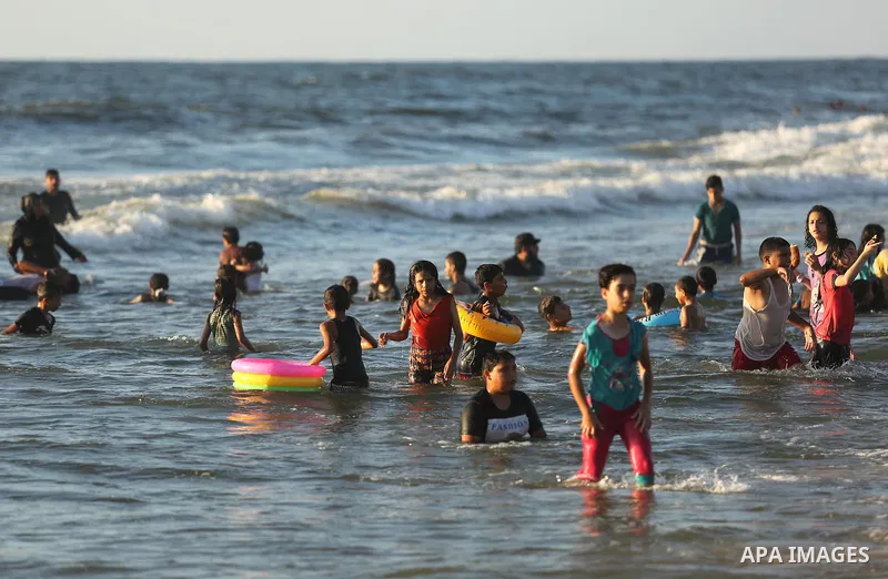 Palestinians enjoy their time at the beach of the Mediterranean sea on the coast of Gaza city on August 4, 2017. Photo by Ashraf Amra