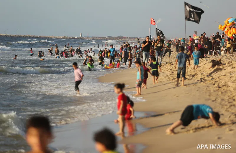 Palestinians enjoy their time at the beach of the Mediterranean sea on the coast of Gaza city on August 4, 2017. Photo by Ashraf Amra
