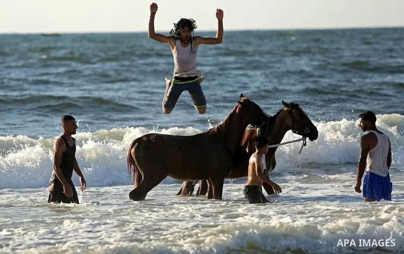 Palestinians enjoy their time at the beach of the Mediterranean sea on the coast of Gaza city on August 4, 2017. Photo by Ashraf Amra