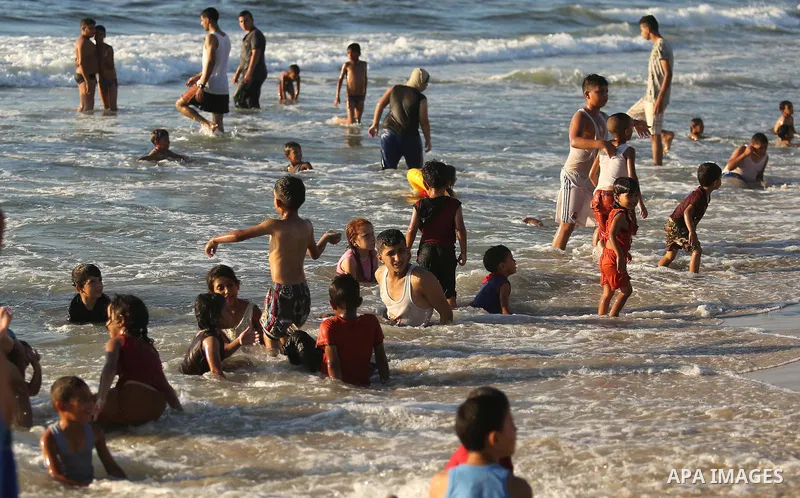 Palestinians enjoy their time at the beach of the Mediterranean sea on the coast of Gaza city on August 4, 2017. Photo by Ashraf Amra