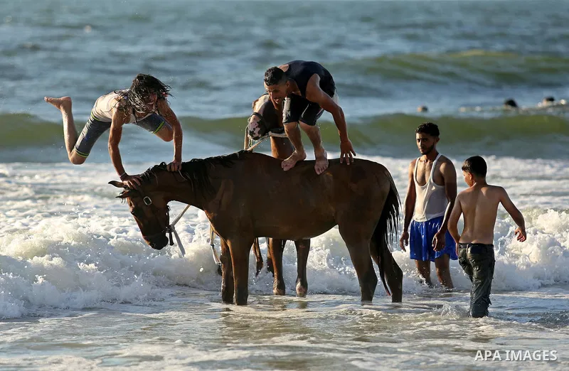 Palestinians enjoy their time at the beach of the Mediterranean sea on the coast of Gaza city on August 4, 2017. Photo by Ashraf Amra
