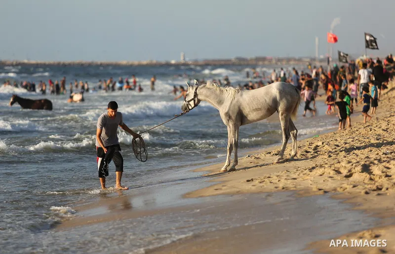 Palestinians enjoy their time at the beach of the Mediterranean sea on the coast of Gaza city on August 4, 2017. Photo by Ashraf Amra
