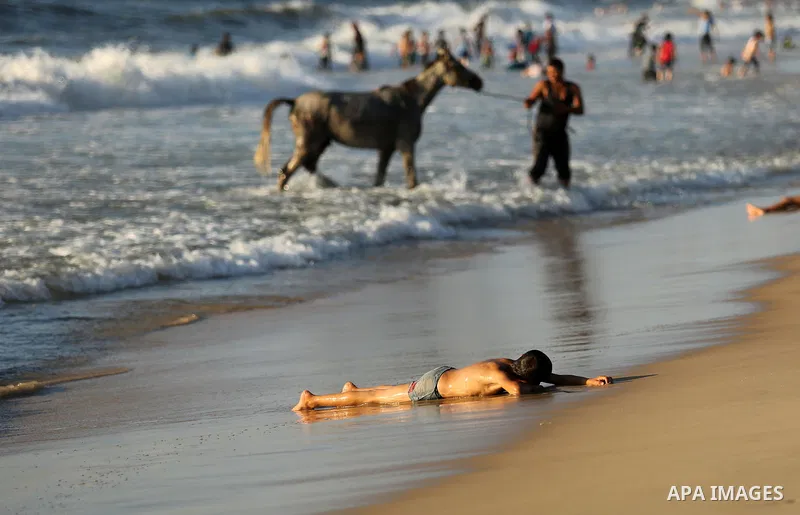 Palestinians enjoy their time at the beach of the Mediterranean sea on the coast of Gaza city on August 4, 2017. Photo by Ashraf Amra