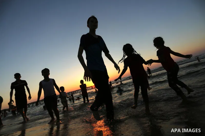 Palestinians enjoy their time at the beach of the Mediterranean sea on the coast of Gaza city on August 4, 2017. Photo by Ashraf Amra