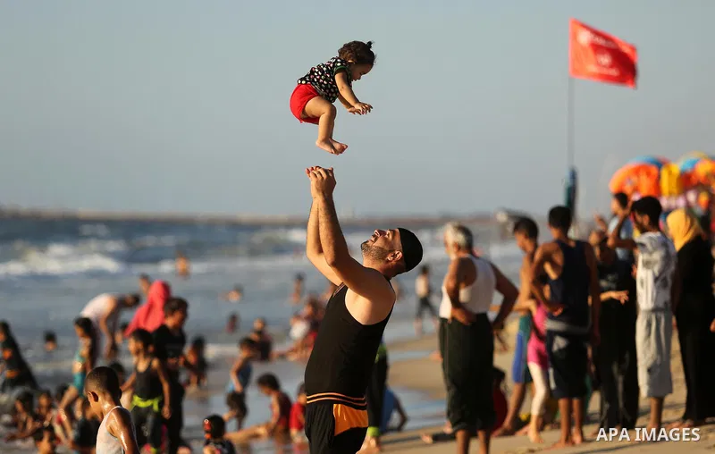 Palestinians enjoy their time at the beach of the Mediterranean sea on the coast of Gaza city on August 4, 2017. Photo by Ashraf Amra