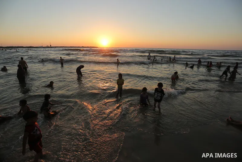 Palestinians enjoy their time at the beach of the Mediterranean sea on the coast of Gaza city on August 4, 2017. Photo by Ashraf Amra