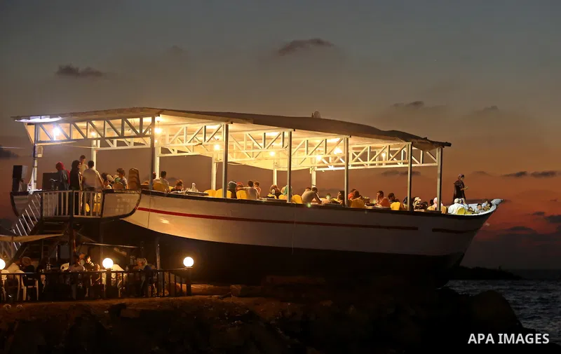 Palestinians are seen aboard "Lolo Rose" ship which has become a popular restaurant, on a beach in Gaza City on August 4, 2017. Photo by Ashraf Amra