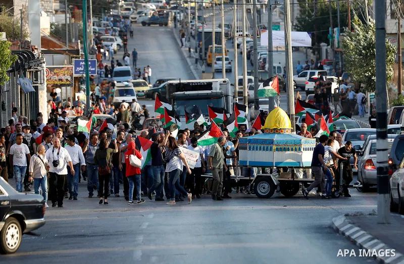 Palestinian protesters hold palestine flags during a demonstration against new Israeli security measures at the Al-Aqsa mosque compound in Jerusalem in the West Bank city of Bethlehem July 19, 2017. Photo by Wisam Hashla...
