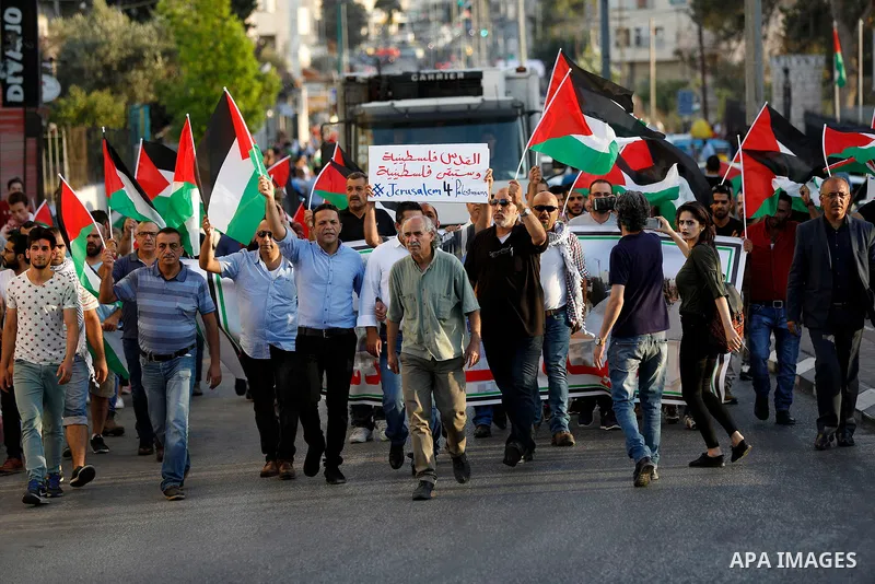 Palestinian protesters hold palestine flags during a demonstration against new Israeli security measures at the Al-Aqsa mosque compound in Jerusalem in the West Bank city of Bethlehem July 19, 2017. Photo by Wisam Hashla...