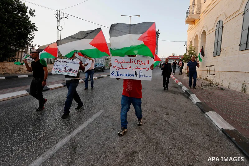 Palestinian protesters hold palestine flags during a demonstration against new Israeli security measures at the Al-Aqsa mosque compound in Jerusalem in the West Bank city of Bethlehem July 19, 2017. Photo by Wisam Hashla...