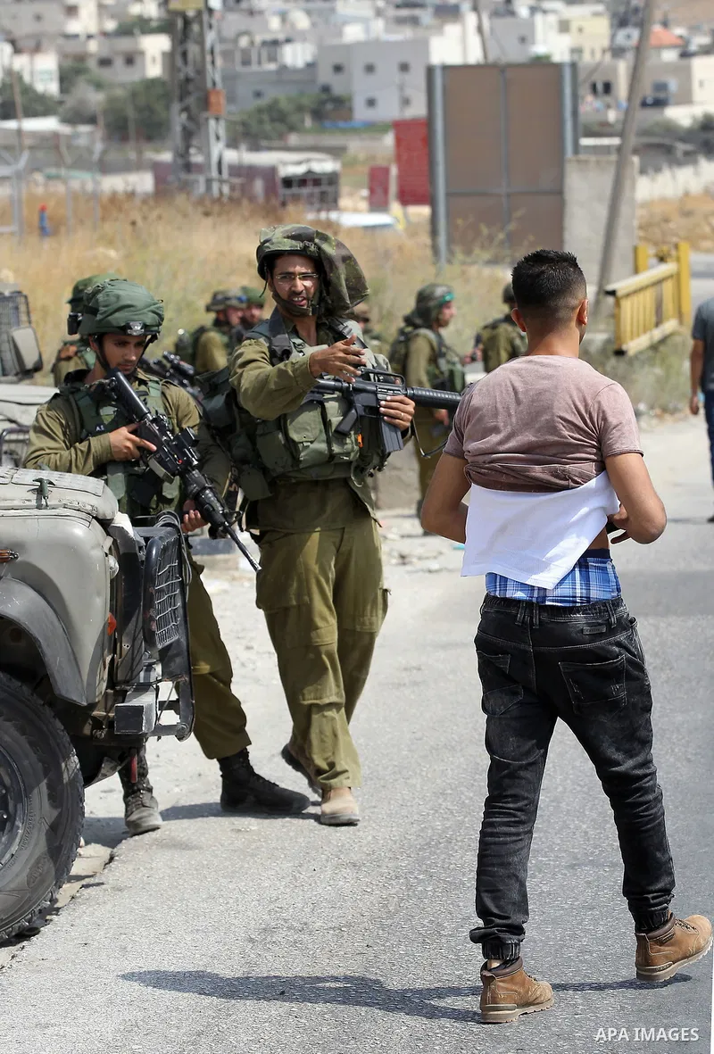 An Israeli soldier searches a Palestinian man at a temporary checkpoint near the West Bank town of Dura, south of Hebron , 24 July 2017. Photo by Wisam Hashlamoun