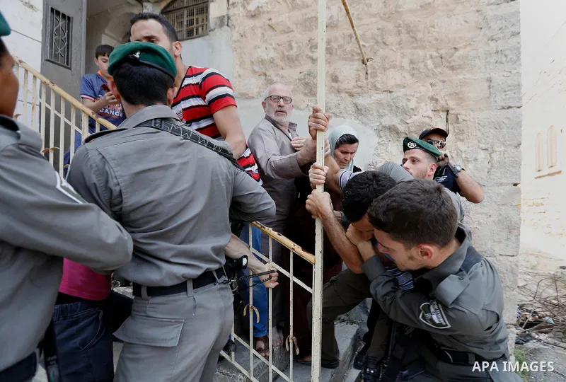 Israeli police officers scuffle with Palestinians as they police try to detain them in the West Bank city of Hebron July 26, 2017. Photo by Wisam Hashlamoun