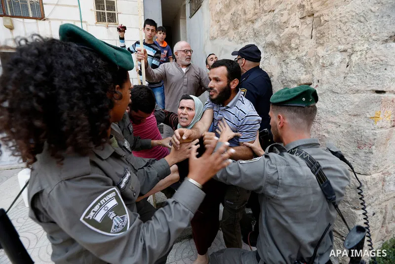 Israeli police officers scuffle with Palestinians as they police try to detain them in the West Bank city of Hebron July 26, 2017. Photo by Wisam Hashlamoun