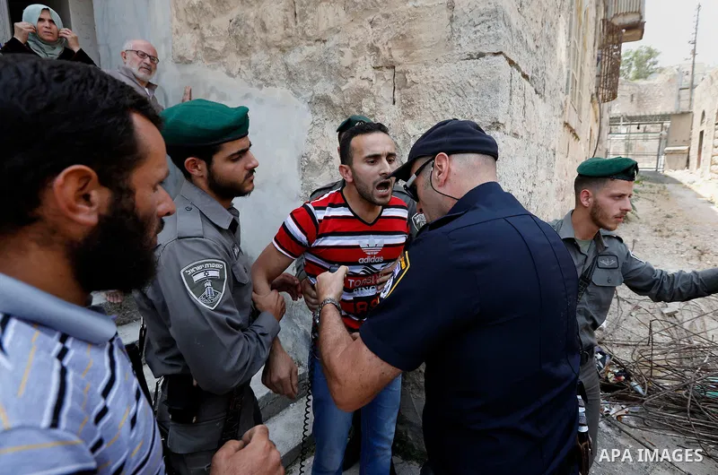 Israeli police officers scuffle with Palestinians as they police try to detain them in the West Bank city of Hebron July 26, 2017. Photo by Wisam Hashlamoun