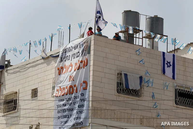 Israeli border police officers set up a barricade in front of a disputed building where about a hundred hard-line Jewish settlers have hunkered down, in the West Bank city of Hebron July 26, 2017. Photo by Wisam Hashlamo...