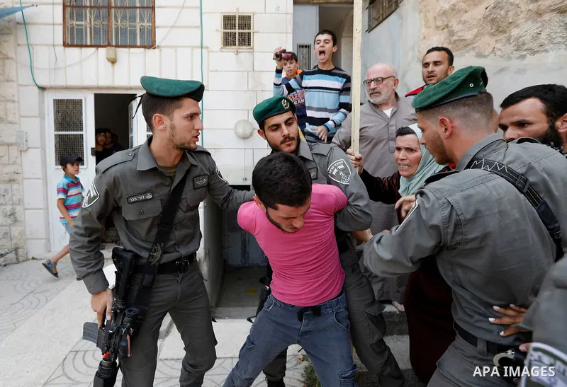 Israeli police officers scuffle with Palestinians as they police try to detain them in the West Bank city of Hebron July 26, 2017. Photo by Wisam Hashlamoun