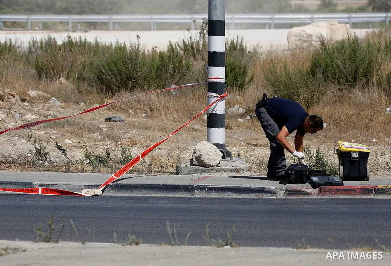 Israeli forensic policemen inspect the place where a 24-year-old Palestinian attempted to stab Israeli soldiers and was shot dead by security forces, at the Gush Etzion junction, a settlement bloc next to the biblical Pa...