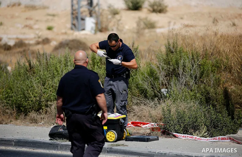 Israeli forensic policemen inspect the place where a 24-year-old Palestinian attempted to stab Israeli soldiers and was shot dead by security forces, at the Gush Etzion junction, a settlement bloc next to the biblical Pa...