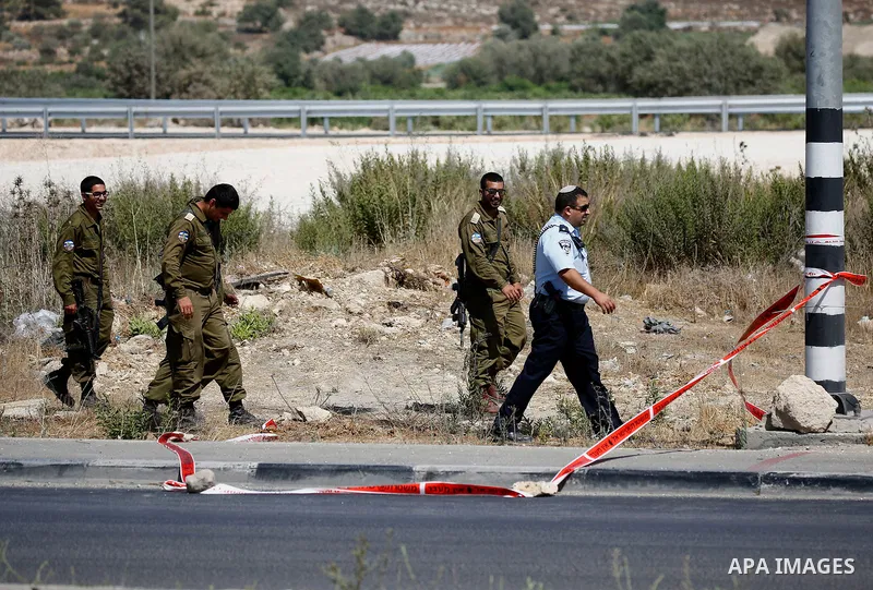 Israeli forensic policemen inspect the place where a 24-year-old Palestinian attempted to stab Israeli soldiers and was shot dead by security forces, at the Gush Etzion junction, a settlement bloc next to the biblical Pa...