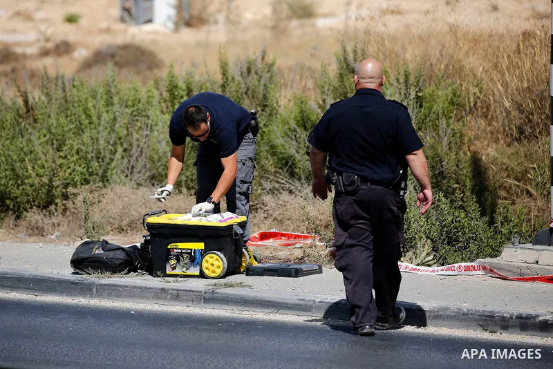 Israeli forensic policemen inspect the place where a 24-year-old Palestinian attempted to stab Israeli soldiers and was shot dead by security forces, at the Gush Etzion junction, a settlement bloc next to the biblical Pa...