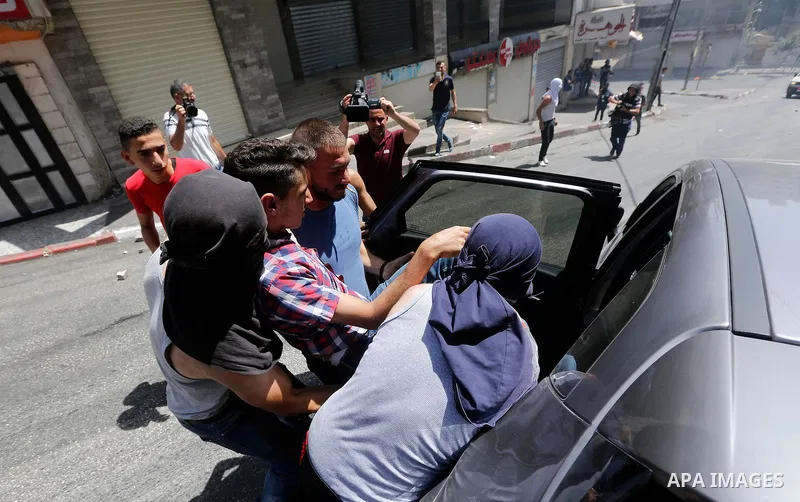 Palestinian protesters hurl stones during clashes between demonstrators and Israeli security forces in the city of Hebron in the Israeli-occupied West Bank, on July 28, 2017, as protests erupt in support of the Al-Aqsa m...