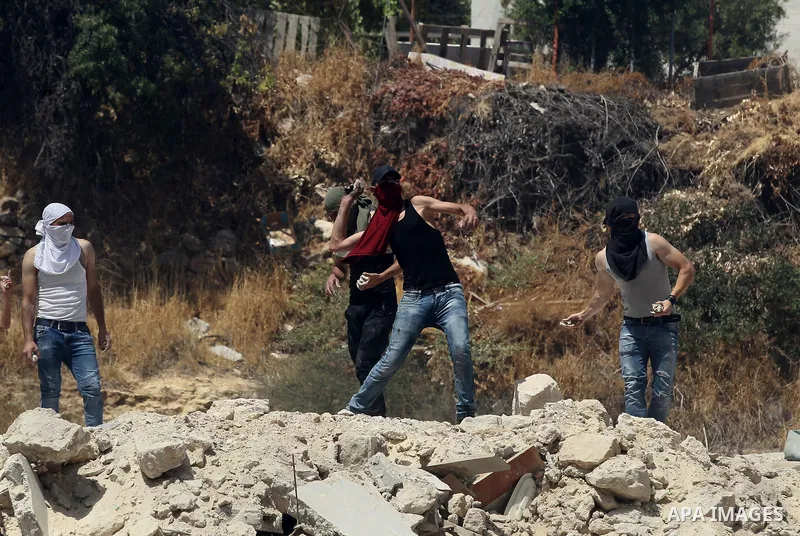Palestinian protesters hurl stones during clashes between demonstrators and Israeli security forces in the city of Hebron in the Israeli-occupied West Bank, on July 28, 2017, as protests erupt in support of the Al-Aqsa m...
