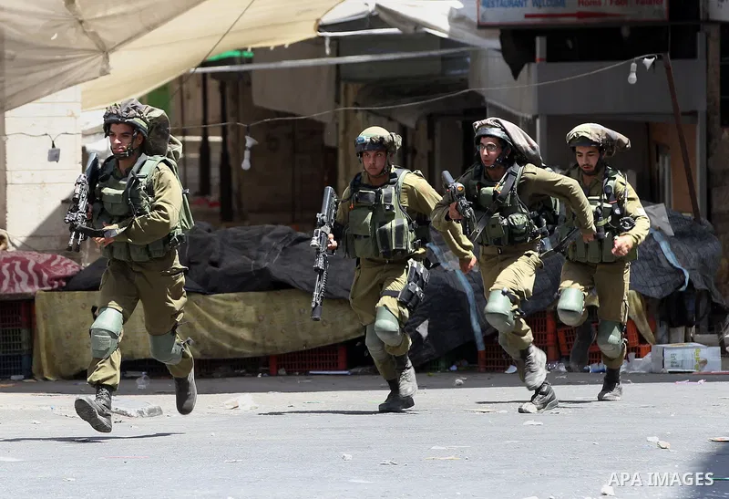 Israeli forces fire towards Palestinian demonstrators during clashes in the city of Hebron in the Israeli-occupied West Bank, on July 28, 2017, as protests erupt in support of the Al-Aqsa mosque compound after Israeli po...