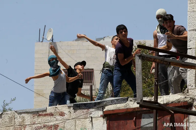 Palestinian protesters hurl stones during clashes between demonstrators and Israeli security forces in the city of Hebron in the Israeli-occupied West Bank, on July 28, 2017, as protests erupt in support of the Al-Aqsa m...
