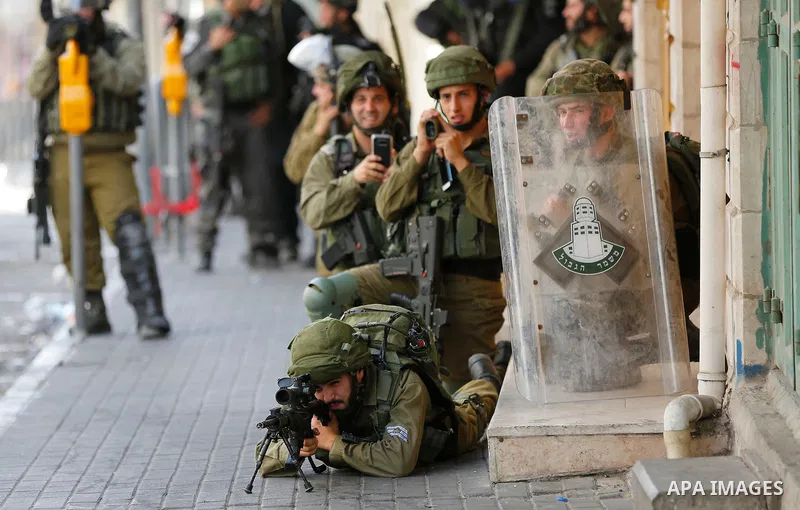 Israeli forces fire towards Palestinian demonstrators during clashes in the city of Hebron in the Israeli-occupied West Bank, on July 28, 2017, as protests erupt in support of the Al-Aqsa mosque compound after Israeli po...