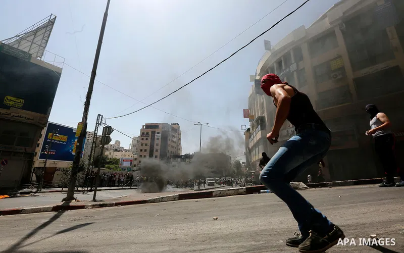 Palestinian protesters hurl stones during clashes between demonstrators and Israeli security forces in the city of Hebron in the Israeli-occupied West Bank, on July 28, 2017, as protests erupt in support of the Al-Aqsa m...
