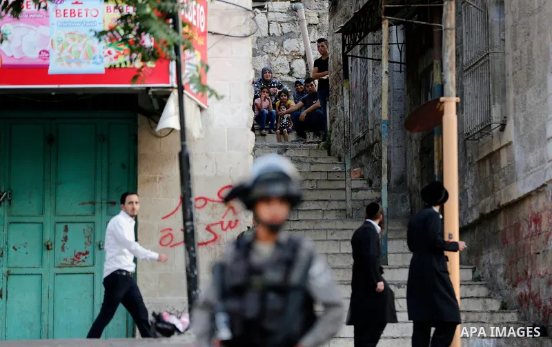 Israeli soldier stand guard while Ultra-Orthodox Jewish men under the protection of the soldiers visit a sacred Jewish site in the occupied West Bank city of Hebron, 01 August 2017. Photo by Wisam Hashlamoun