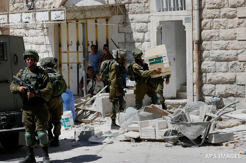 Israeli security forces confiscate files and cam recorders during a raid on the Palestinians committee of security in H2 area in the West bank city of Hebron on August 2, 2017. The H2 area is inhabited by approximately 3...