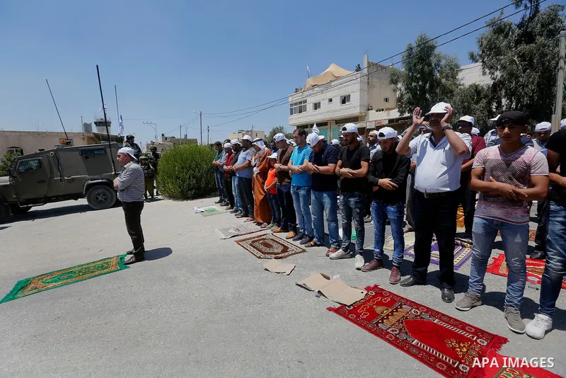 Palestinian protesters perform Friday Prayer during a protest against building a new Israeli military tower in the West Bank town of Dura, south of Hebron August 4, 2017. Photo by Wisam Hashlamoun