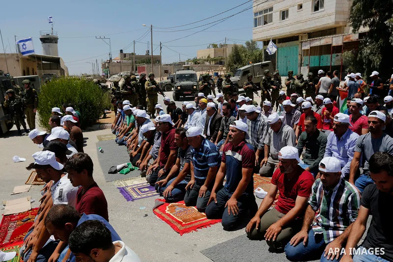 Palestinian protesters perform Friday Prayer during a protest against building a new Israeli military tower in the West Bank town of Dura, south of Hebron August 4, 2017. Photo by Wisam Hashlamoun