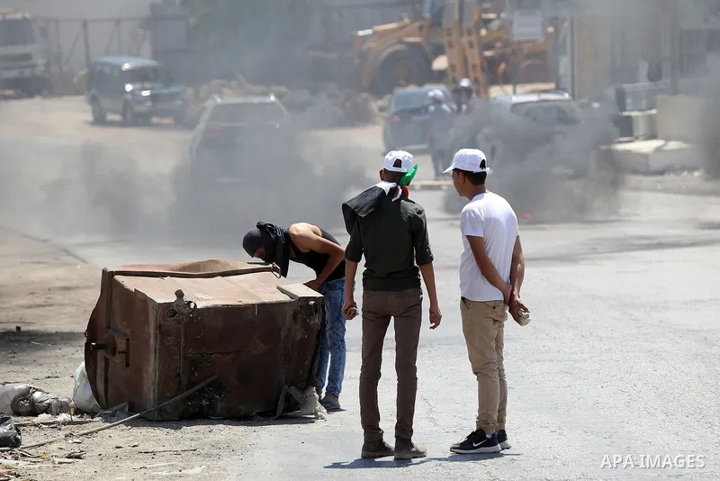 Palestinian protesters burn a tyre during a protest against building a new Israeli military tower in the West Bank town of Dura, south of Hebron August 4, 2017. Photo by Wisam Hashlamoun