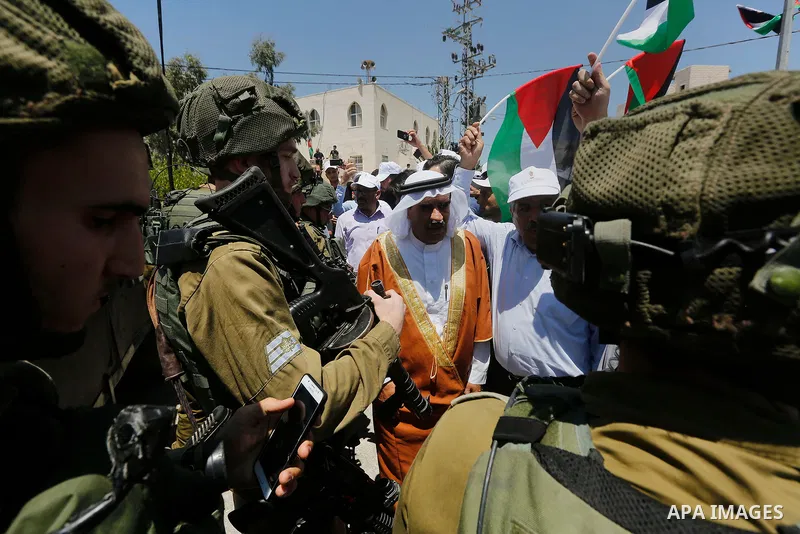 Palestinian protesters shout in front of Israeli soldiers during a protest against building a new Israeli military tower in the West Bank town of Dura, south of Hebron August 4, 2017. Photo by Wisam Hashlamoun