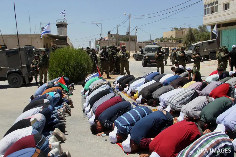 Palestinian protesters perform Friday Prayer during a protest against building a new Israeli military tower in the West Bank town of Dura, south of Hebron August 4, 2017. Photo by Wisam Hashlamoun