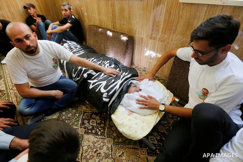 Palestinians mourn around the body of Palestinian Rafat Herbawi who had been killed in July 19 by Israeli soldiers after allegedly attempting car- ramming attack during his funeral in the West Bank of Hebron, on August 5...
