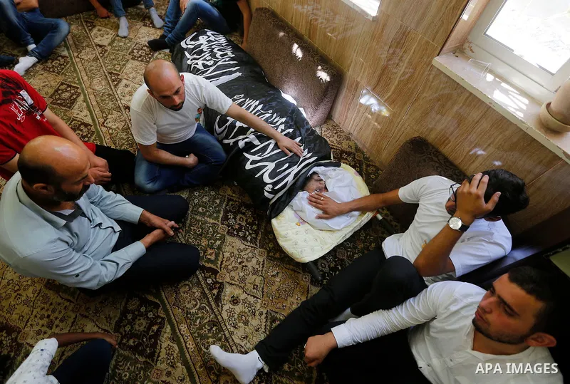 Palestinians mourn around the body of Palestinian Rafat Herbawi who had been killed in July 19 by Israeli soldiers after allegedly attempting car- ramming attack during his funeral in the West Bank of Hebron, on August 5...